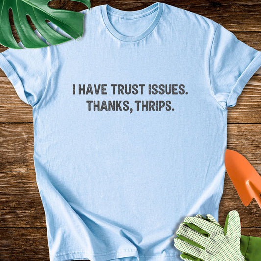 Light blue T-shirt with minimalist lettering reading "I Have Trust Issues. Thanks, Thrips.".
