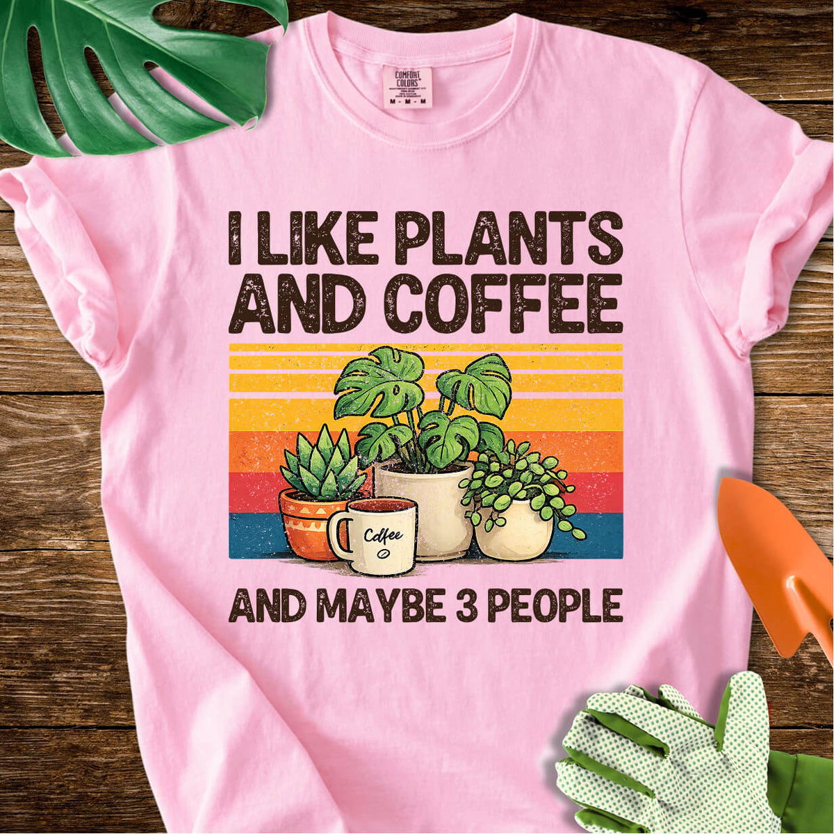 Blossom pink Comfort Colors T-shirt with plants, coffee, and retro stripes with "I Like Plants and Coffee and Maybe 3 People".