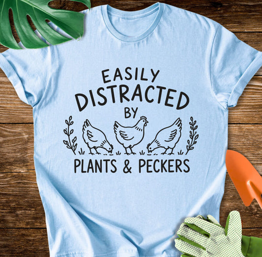 Light blue T-shirt with chickens and leaves with "Easily Distracted by Plants & Peckers".