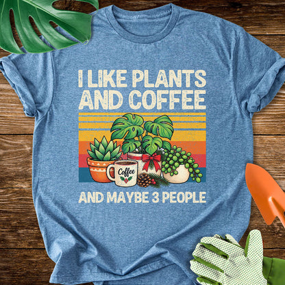 Heather indigo blue T-shirt with Christmas plants and coffee with "I Like Plants and Coffee and Maybe 3 People".