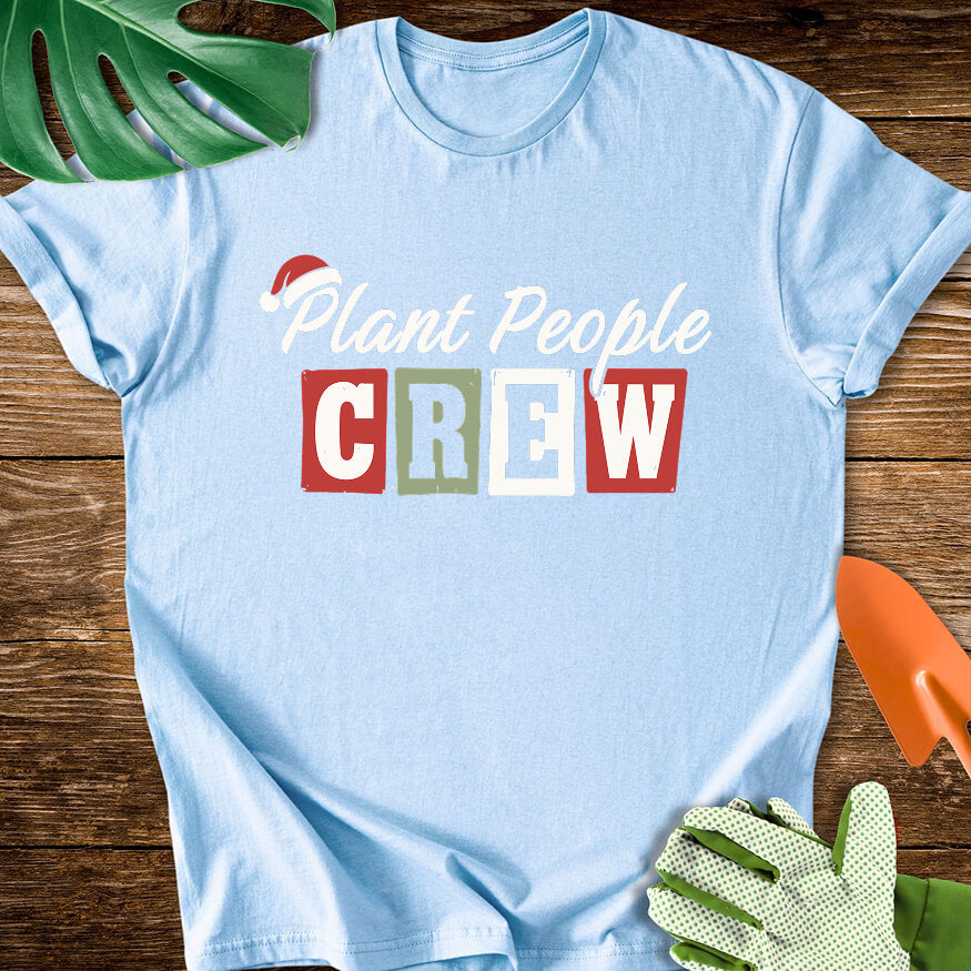 Light blue T-shirt with a Santa hat above festive "Plant People Crew" lettering.