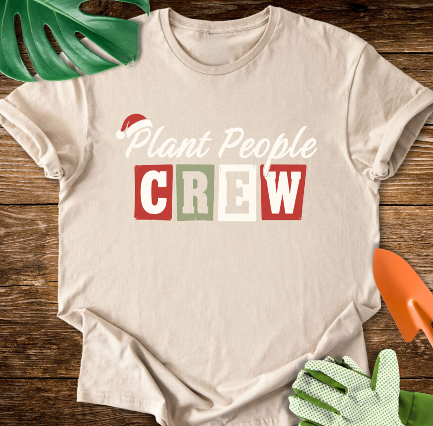 Sand T-shirt with a Santa hat above festive "Plant People Crew" lettering.