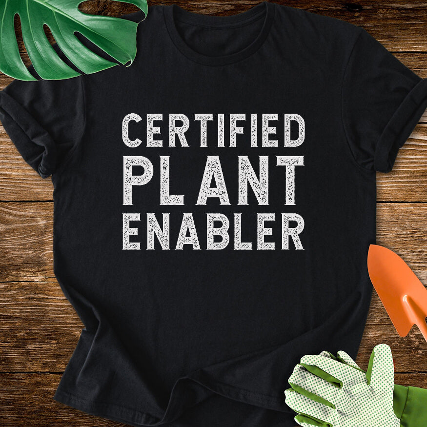 Black T-shirt with bold distressed lettering reading "Certified Plant Enabler".